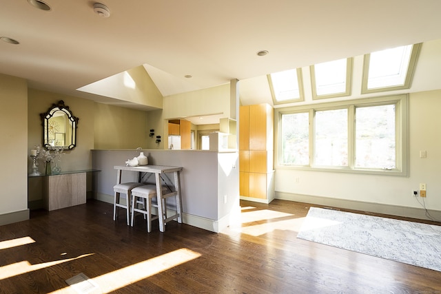kitchen with a peninsula, baseboards, a breakfast bar, and wood finished floors