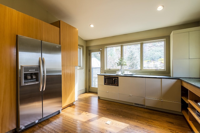 kitchen with recessed lighting, appliances with stainless steel finishes, modern cabinets, and wood finished floors