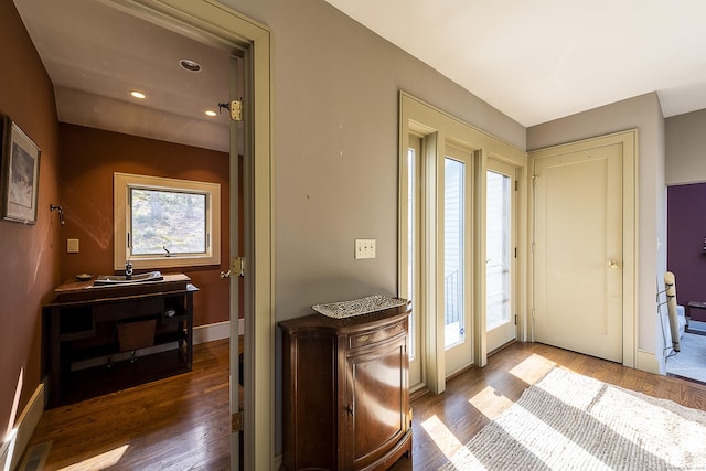 doorway to outside with baseboards, a wealth of natural light, and wood finished floors