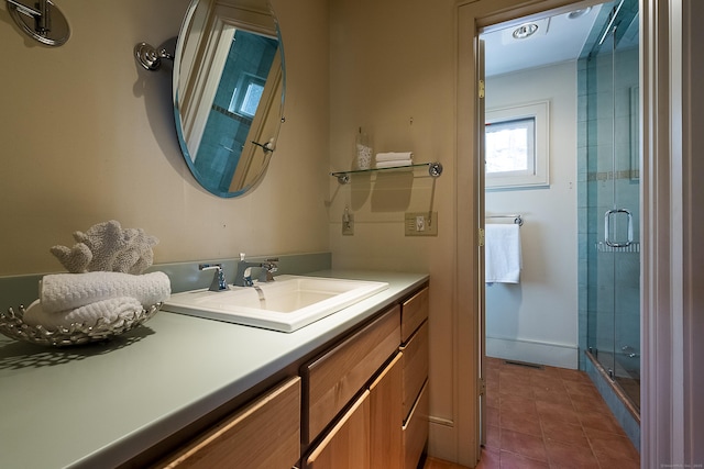 full bath with vanity, baseboards, tile patterned flooring, and a stall shower