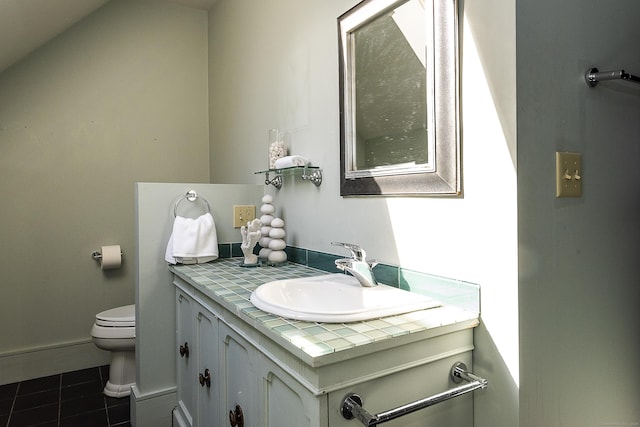 half bathroom with vanity, tile patterned flooring, baseboards, and toilet