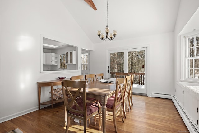 dining room featuring a baseboard radiator, an inviting chandelier, and light hardwood / wood-style floors