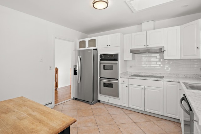 kitchen with stainless steel appliances, white cabinetry, tasteful backsplash, and light tile patterned floors