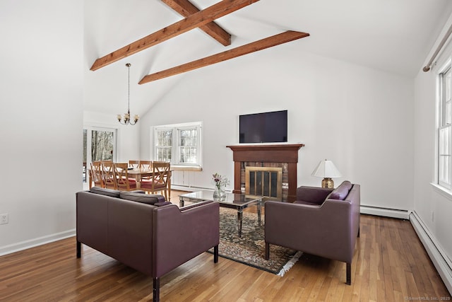 living room with wood-type flooring, beam ceiling, a brick fireplace, and a baseboard heating unit