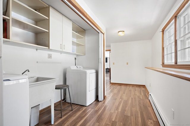 laundry area featuring wood-type flooring, washer / dryer, and a baseboard heating unit