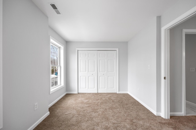 unfurnished bedroom featuring carpet floors and a closet