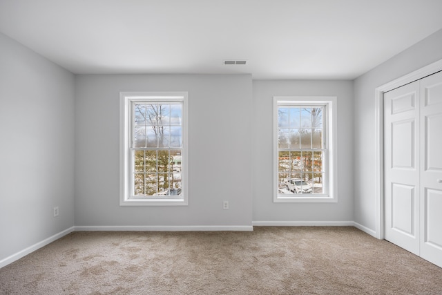 spare room featuring light carpet