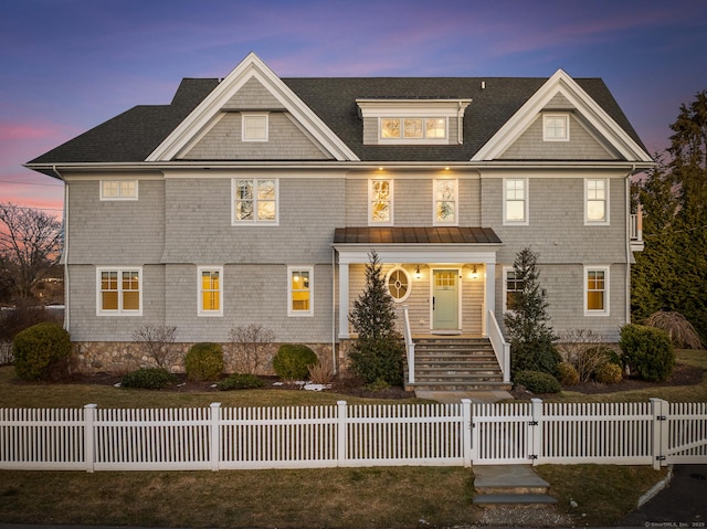 shingle-style home featuring a fenced front yard and a gate