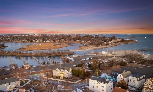 aerial view at dusk featuring a water view