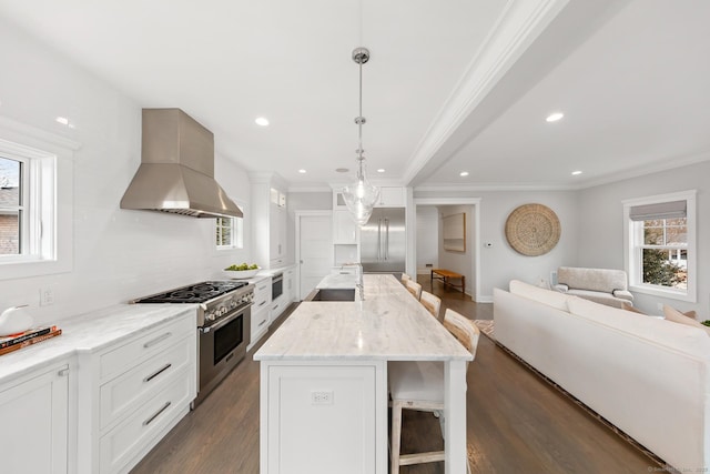 kitchen featuring high end appliances, ornamental molding, open floor plan, dark wood-style flooring, and ventilation hood