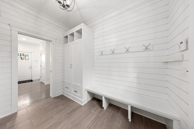 mudroom with crown molding and wood finished floors