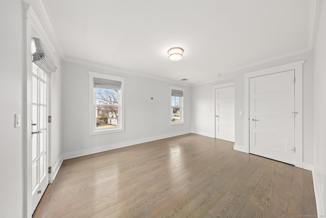 interior space featuring baseboards, crown molding, and wood finished floors