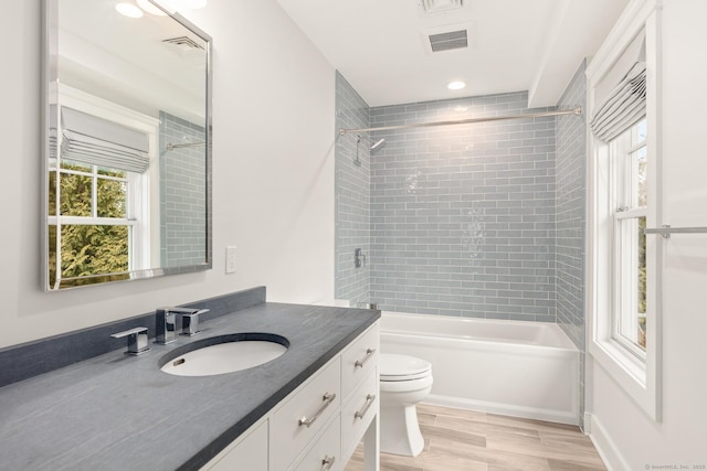 bathroom with toilet, bathtub / shower combination, visible vents, and vanity