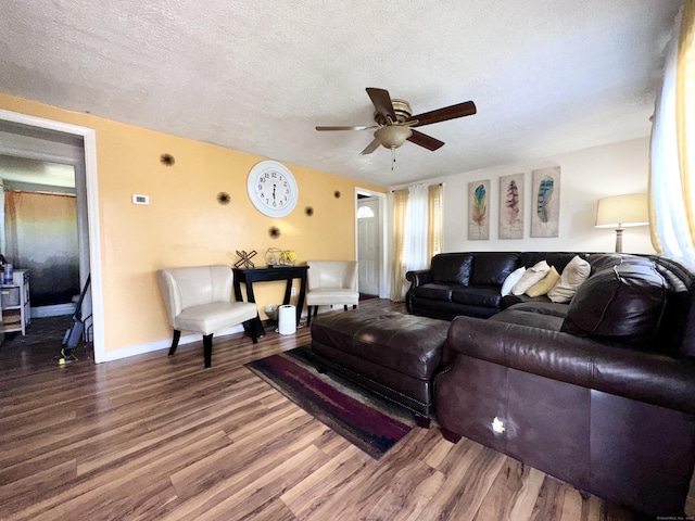 living room featuring ceiling fan, wood-type flooring, and a textured ceiling