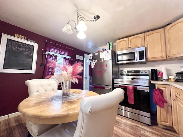 kitchen featuring decorative light fixtures, a chandelier, light hardwood / wood-style flooring, light brown cabinets, and stainless steel appliances