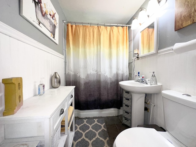 bathroom with shower / tub combo with curtain, tile patterned flooring, and toilet