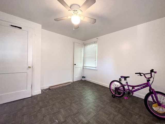 empty room featuring ceiling fan and dark parquet floors