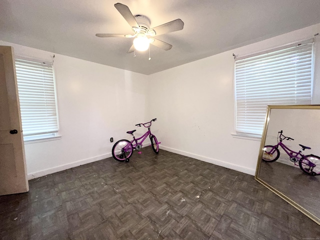 empty room featuring ceiling fan and dark parquet floors