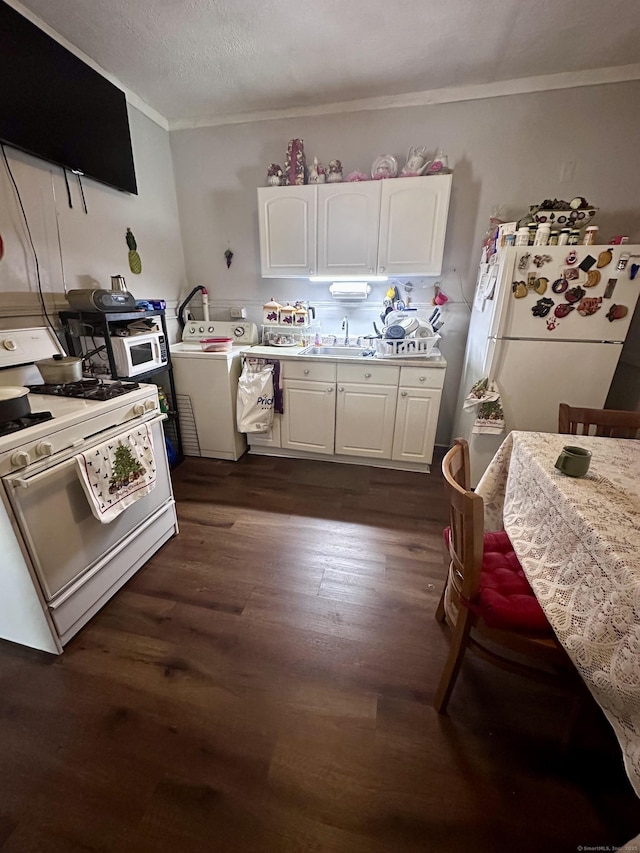 kitchen with dark wood-type flooring, white cabinetry, crown molding, white appliances, and washer / clothes dryer