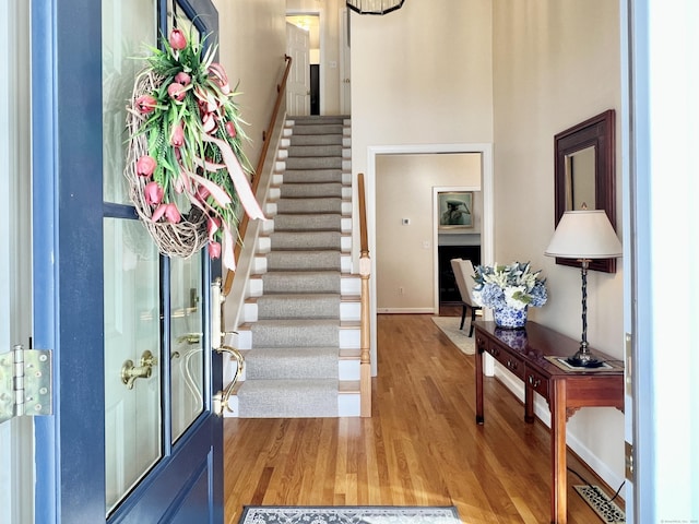 entryway featuring hardwood / wood-style flooring and a towering ceiling