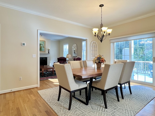 dining room featuring ornamental molding, light hardwood / wood-style flooring, and a notable chandelier