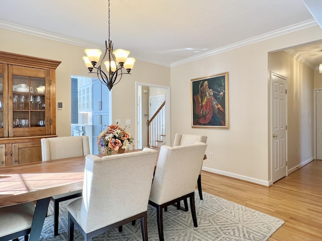 dining area with an inviting chandelier, crown molding, and light hardwood / wood-style floors