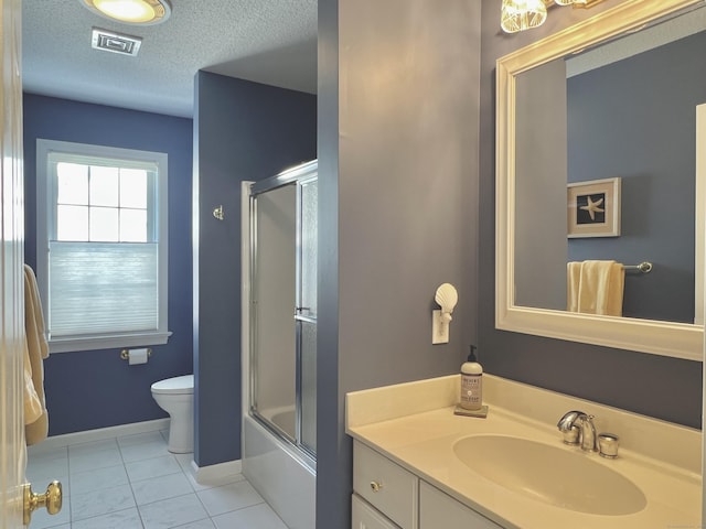 full bathroom featuring enclosed tub / shower combo, vanity, a textured ceiling, tile patterned floors, and toilet