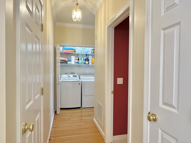 corridor with ornamental molding, washer and clothes dryer, and light hardwood / wood-style flooring