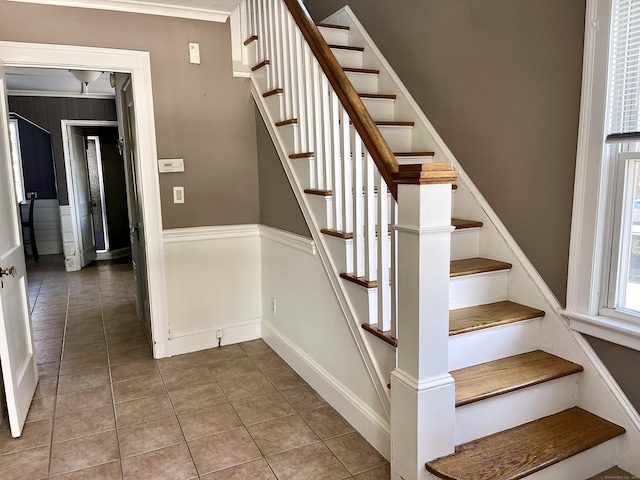 stairway with ornamental molding and tile patterned flooring