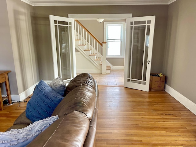 living room with crown molding, light hardwood / wood-style flooring, and french doors