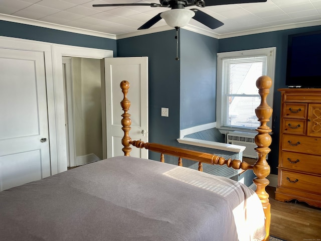 bedroom featuring crown molding, wood-type flooring, cooling unit, and ceiling fan