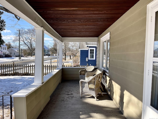 snow covered deck featuring covered porch