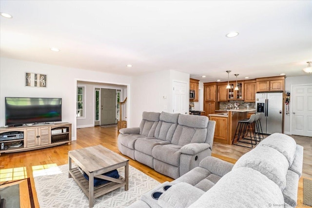 living room with sink and light hardwood / wood-style floors