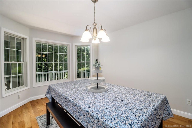 dining space featuring hardwood / wood-style flooring and an inviting chandelier