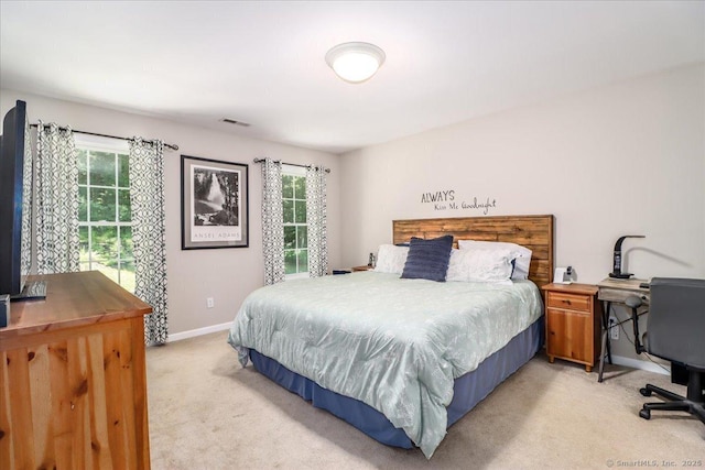 bedroom featuring multiple windows and light colored carpet