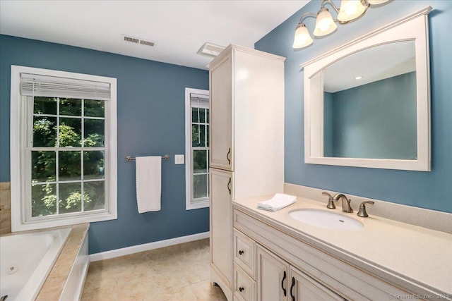 bathroom with vanity, tiled bath, tile patterned flooring, and a wealth of natural light