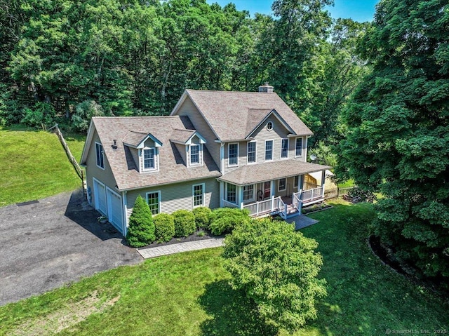 view of front of house featuring a garage, a front yard, and a porch