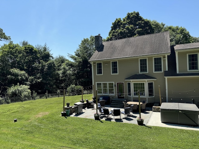 rear view of property featuring a lawn and a patio