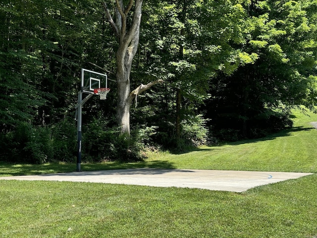 view of basketball court with a yard