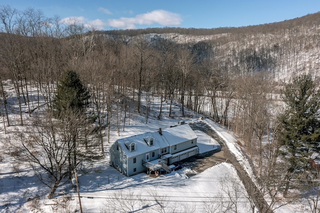 snowy aerial view featuring a forest view