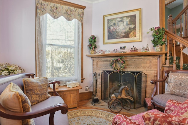 sitting room with a brick fireplace and stairway