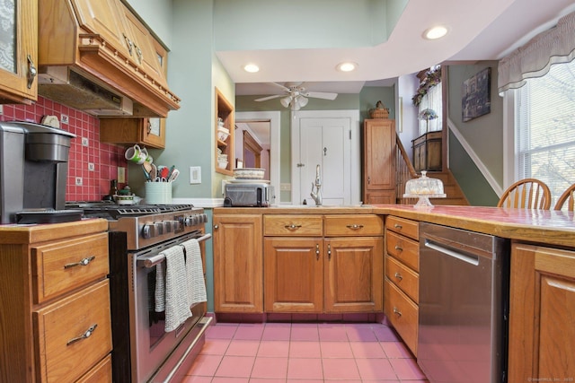 kitchen with brown cabinets, tasteful backsplash, stainless steel appliances, and light tile patterned flooring