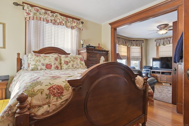 bedroom with multiple windows, light wood-type flooring, and a ceiling fan