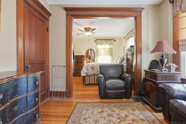 living area with a ceiling fan and light wood-type flooring