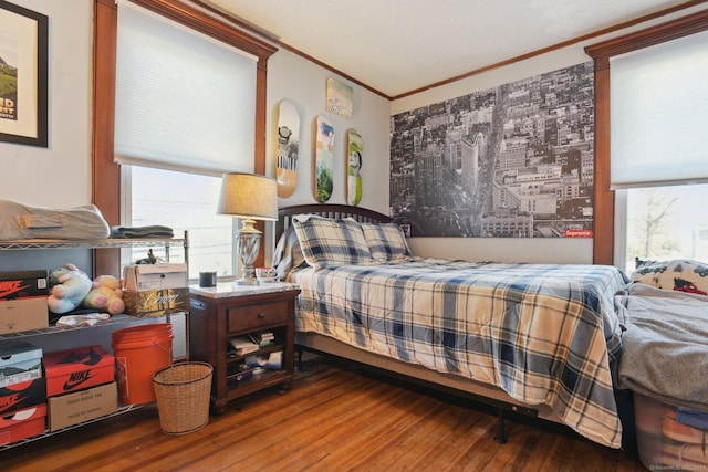 bedroom featuring ornamental molding and wood finished floors