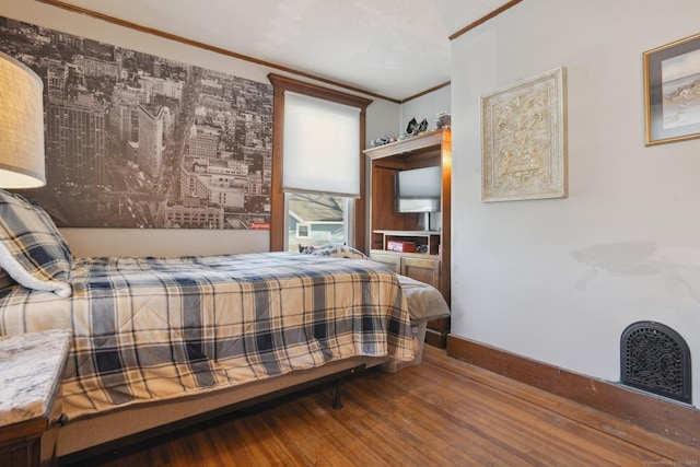 bedroom with crown molding, baseboards, and wood finished floors