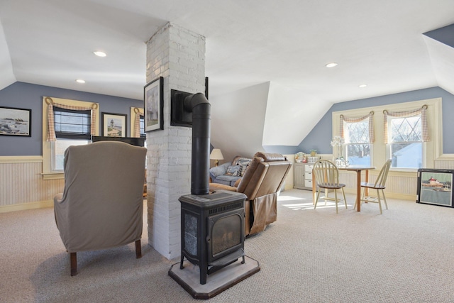 interior space with carpet, recessed lighting, a wood stove, wainscoting, and vaulted ceiling