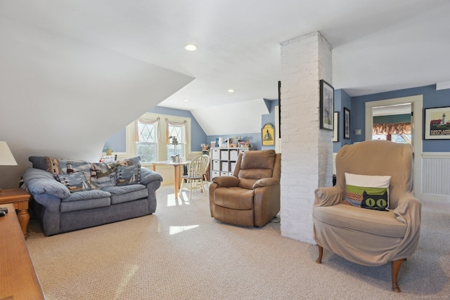 living room featuring lofted ceiling, recessed lighting, carpet floors, wainscoting, and ornate columns