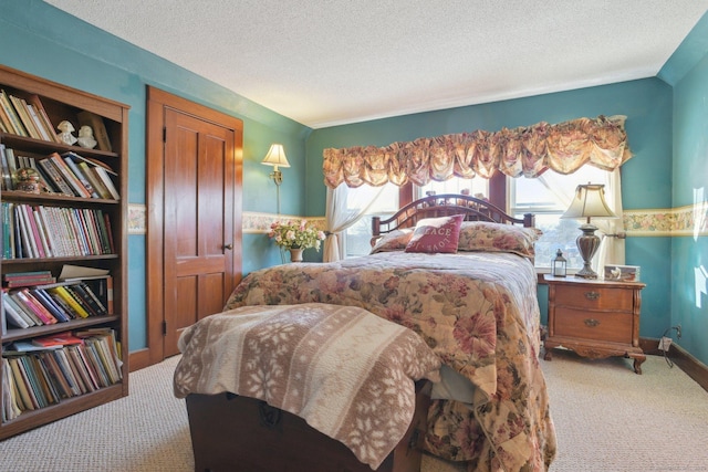 carpeted bedroom with baseboards and a textured ceiling