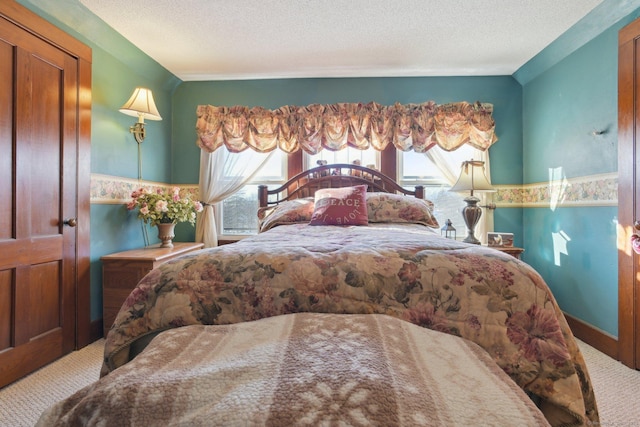 carpeted bedroom with a wainscoted wall, multiple windows, and a textured ceiling